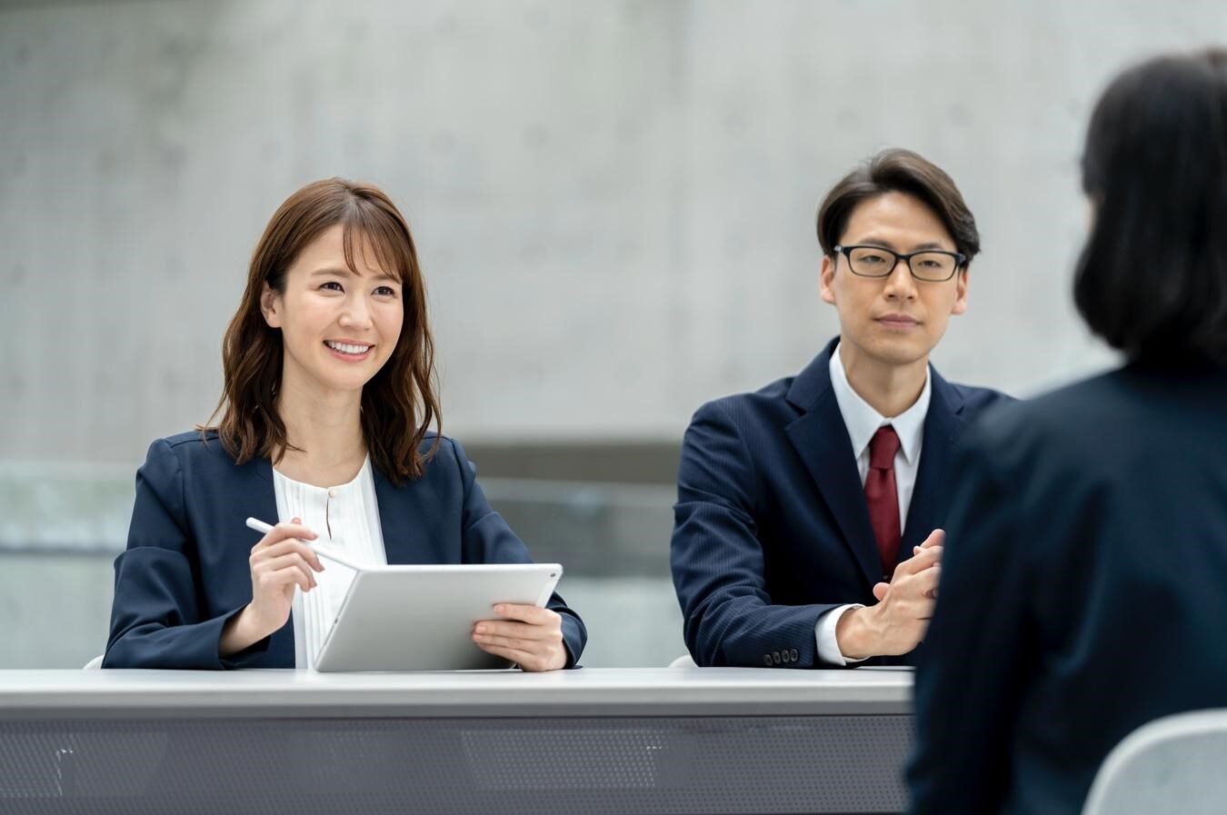 書類を手に面接をするスーツを着た女性と男性