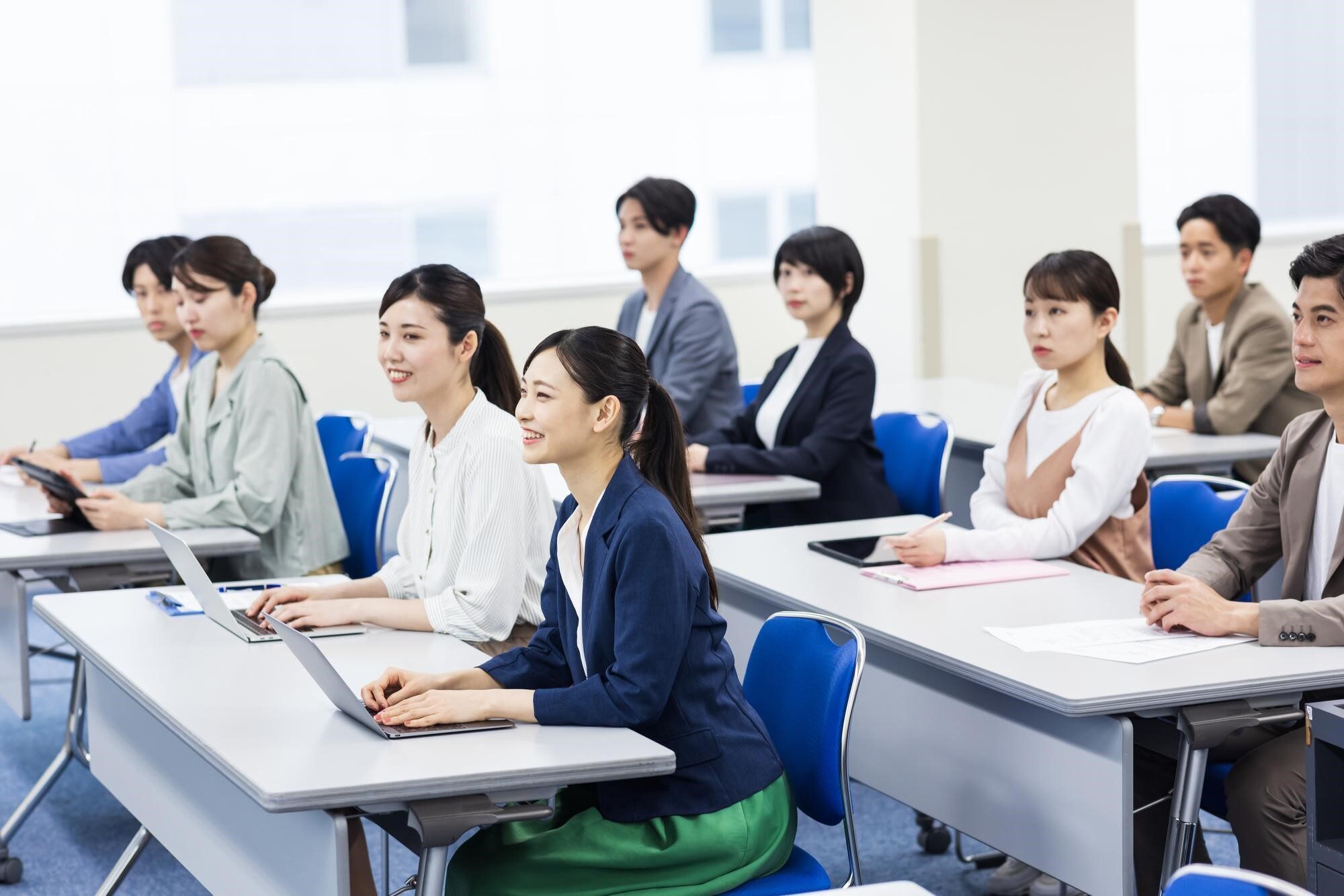 会場で机に向かい講義に耳を傾ける人々