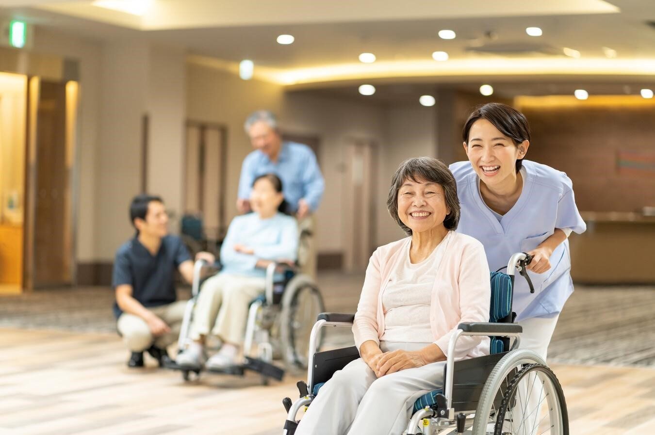 車椅子に乗るシニア女性と車椅子を押す若い女性