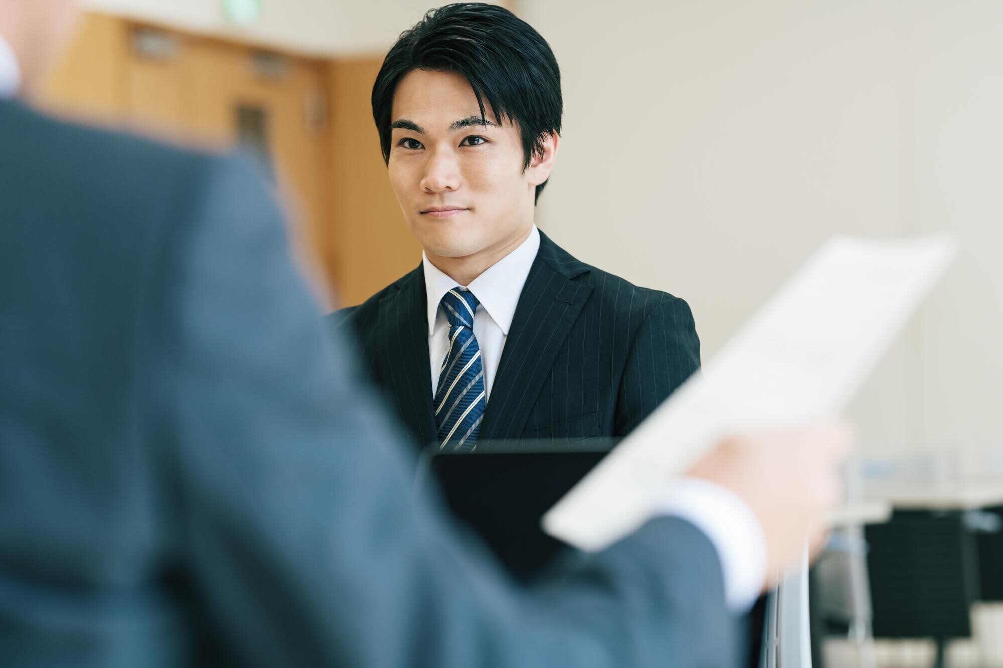 書類を片手に応募者と会話している選考担当者