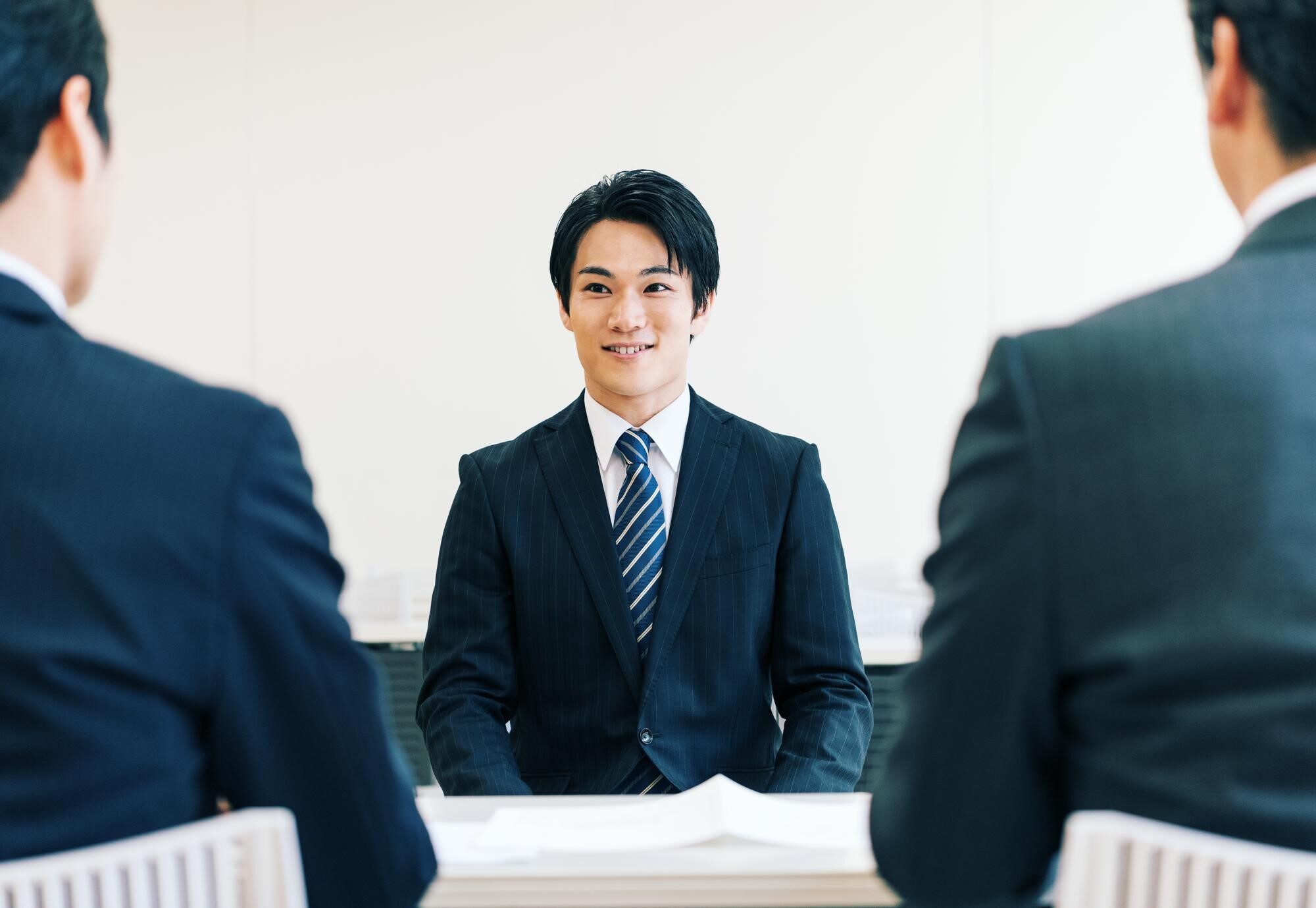 面接に臨む男性と会話する2人の選考担当者