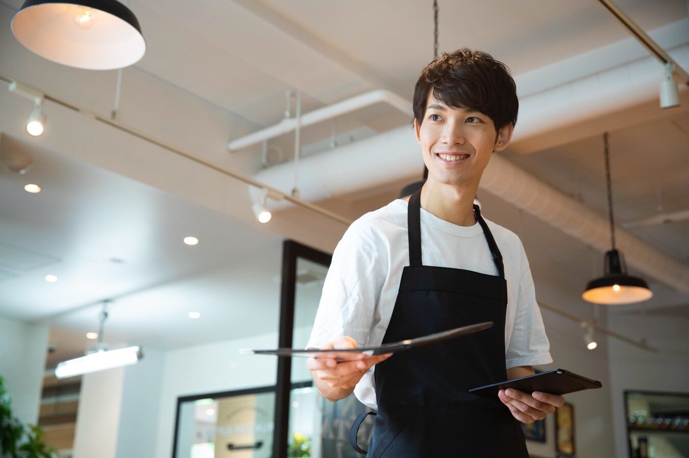 メニューを差し出す笑顔の男性店員