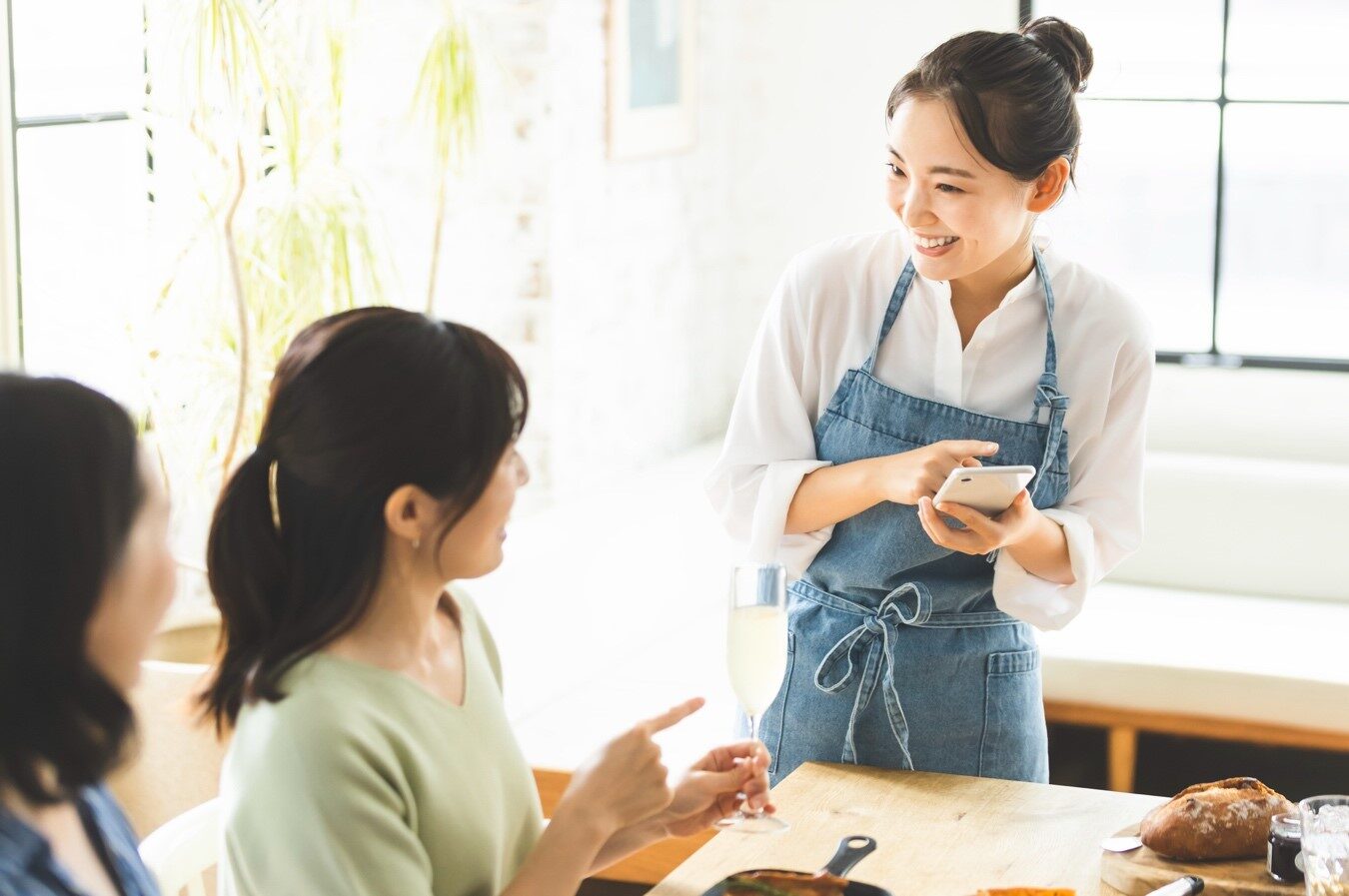 2人の客に注文を聞く女性店員