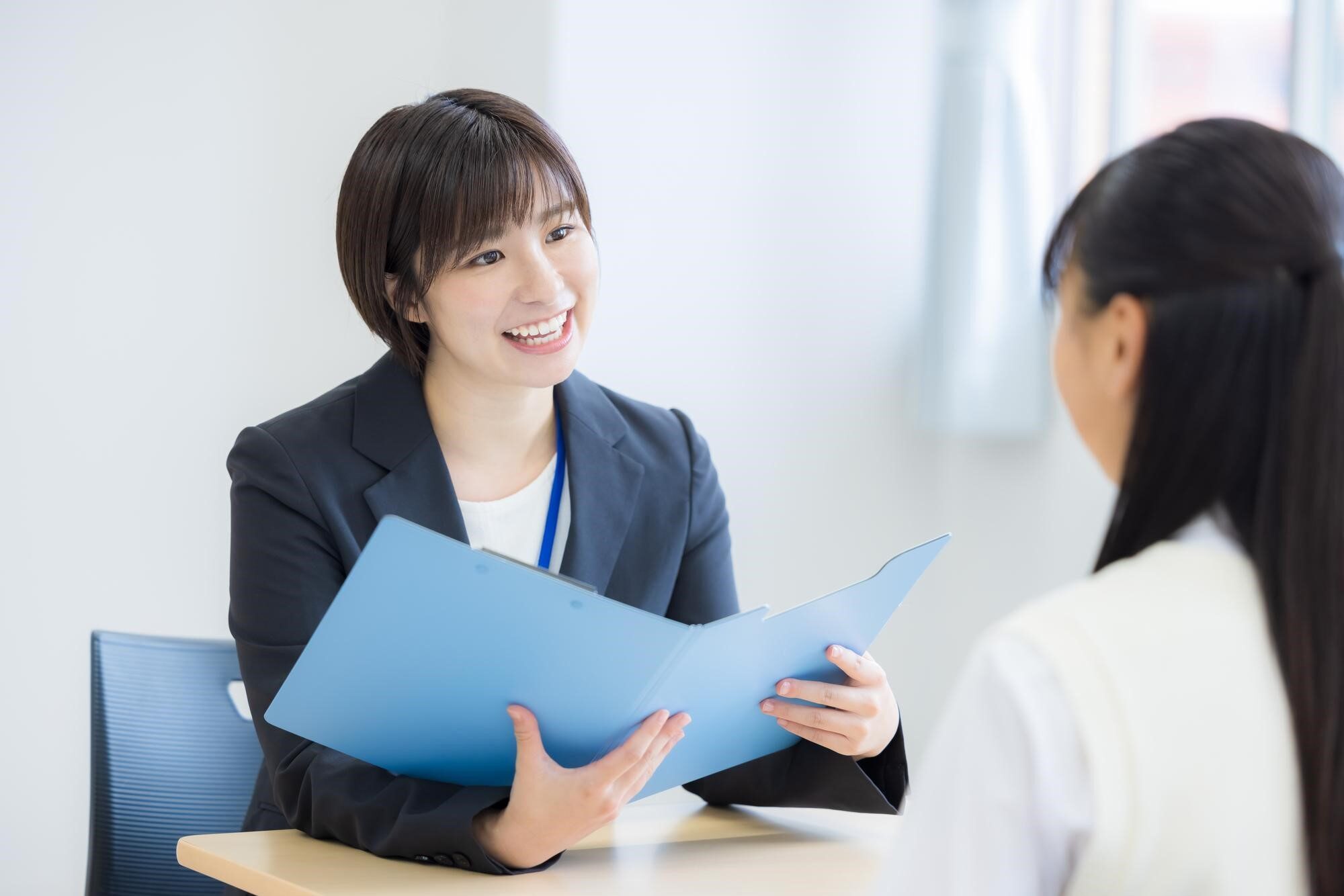 資料を見ながら会話している2人の女性